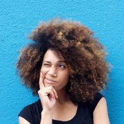 50873851 - portrait of young afro woman thinking against blue background